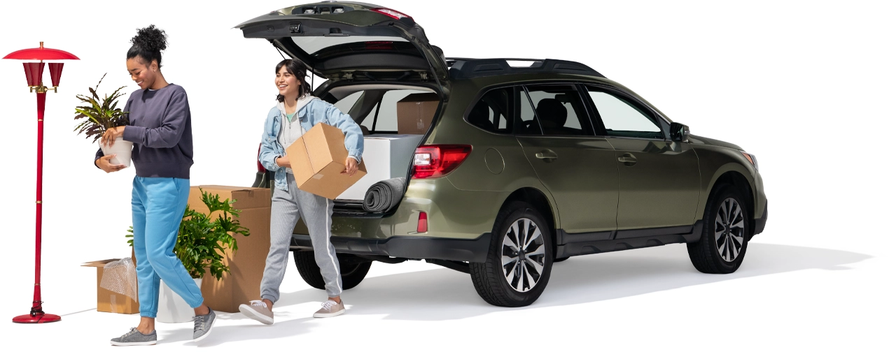 A pair of roommates unpack their SUV. They may save by combining the purchase or their auto and renters insurance.